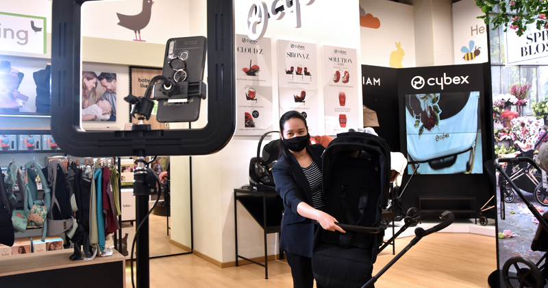 Mothercare staff demonstrating the use of a pram via the Digital Nursery Advisor video call function